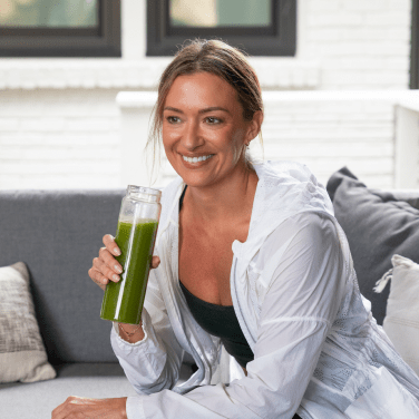 woman holding supergreens in bottle