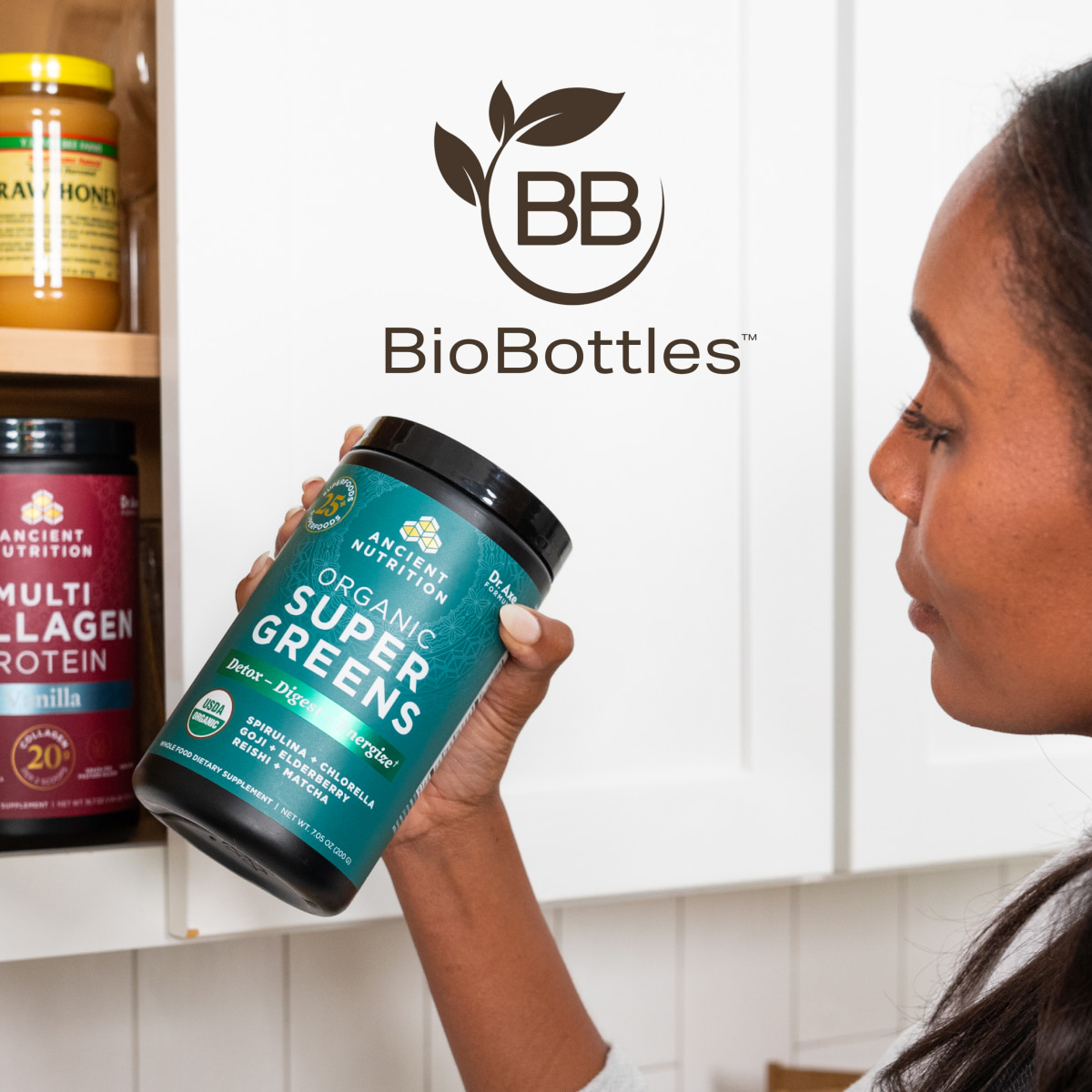 A woman taking out a bottle of Organic SuperGreens from a cabinet with the BioBottle logo overlaid