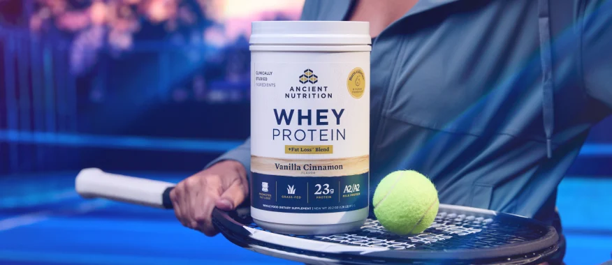 a bottle of whey protein powder on a tennis racquet