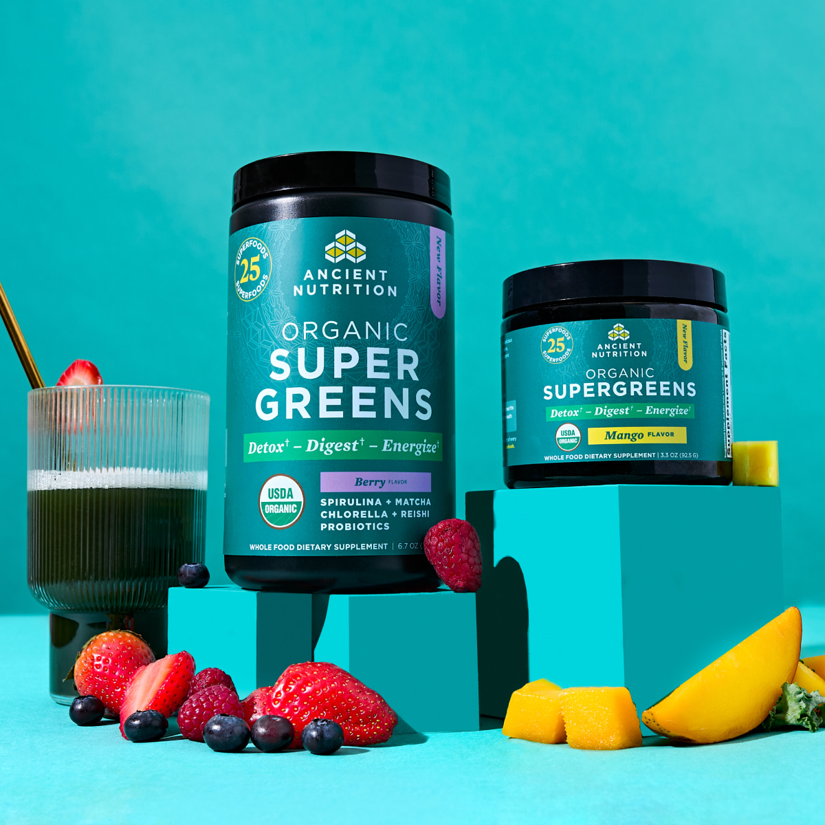 organic supergreens mango and berry bottles on a teal backgrouond