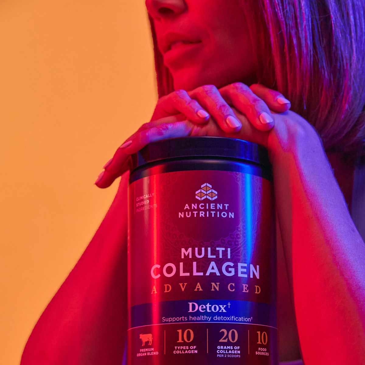 a woman holding a bottle of detox collagen