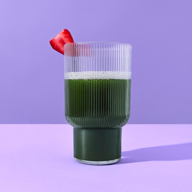 a glass or organic supergreens on a purple background
