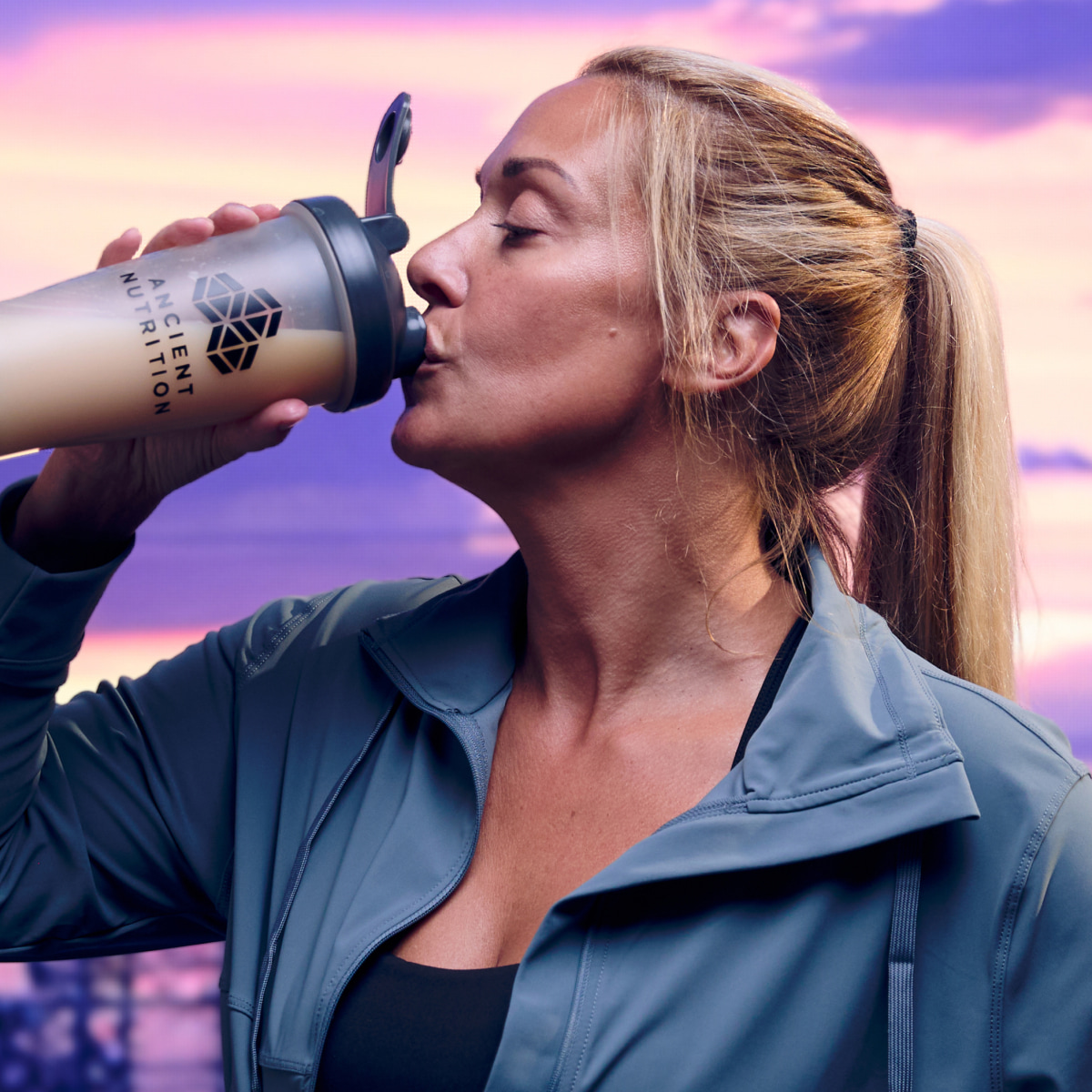 a woman drinking from a shaker bottle