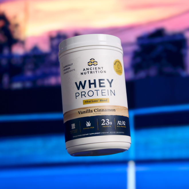 a bottle of whey protein vanilla with a tennis court in the background