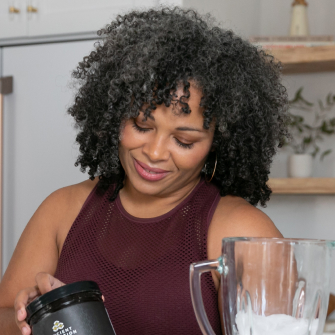 woman adding bone broth to a smoothie