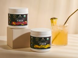 Containers of Ancient Nutrition Organic Fiber and a glass of Organic Fiber mixed with water on a beige background.