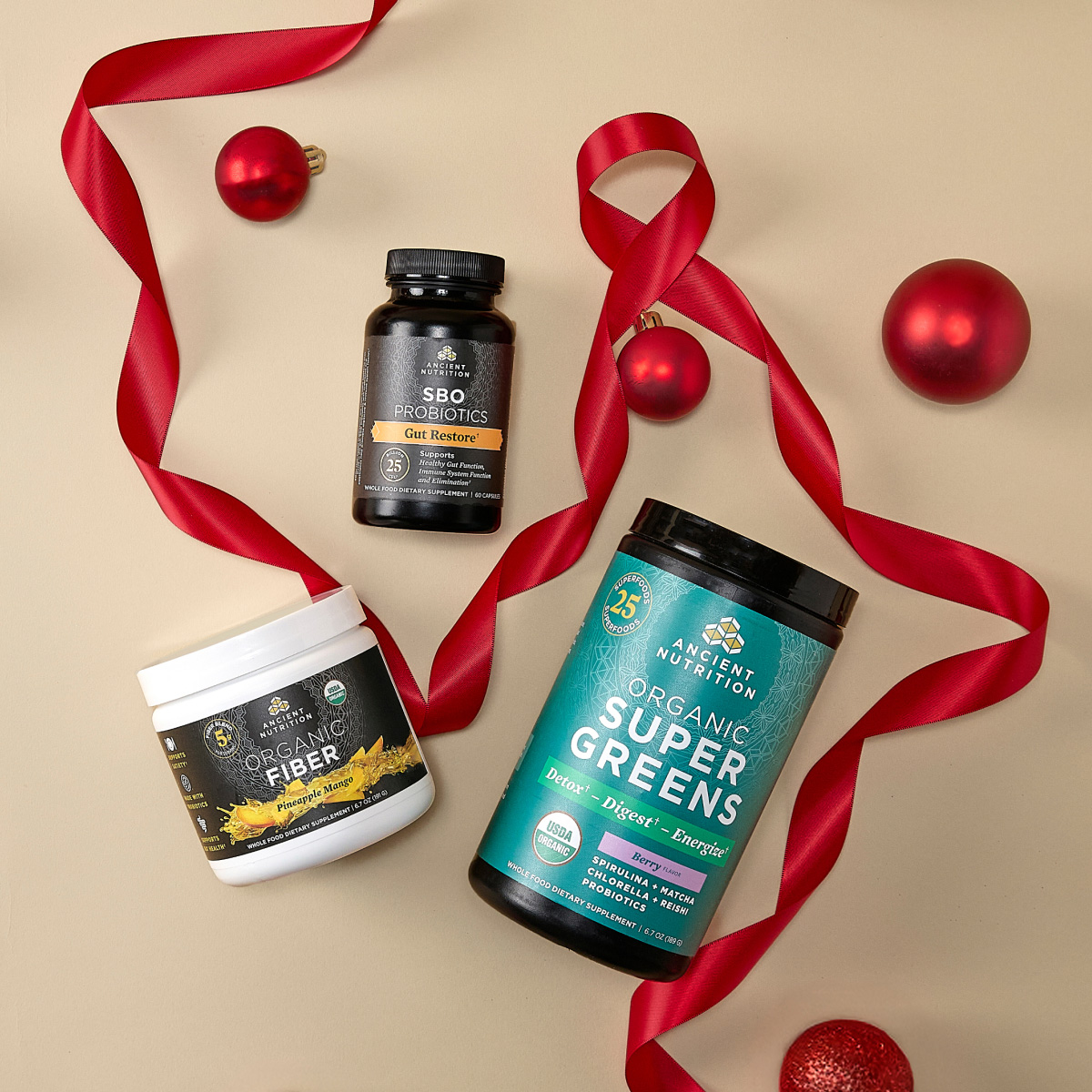 Supergreens, fiber, and sbo probiotics on tan holiday background