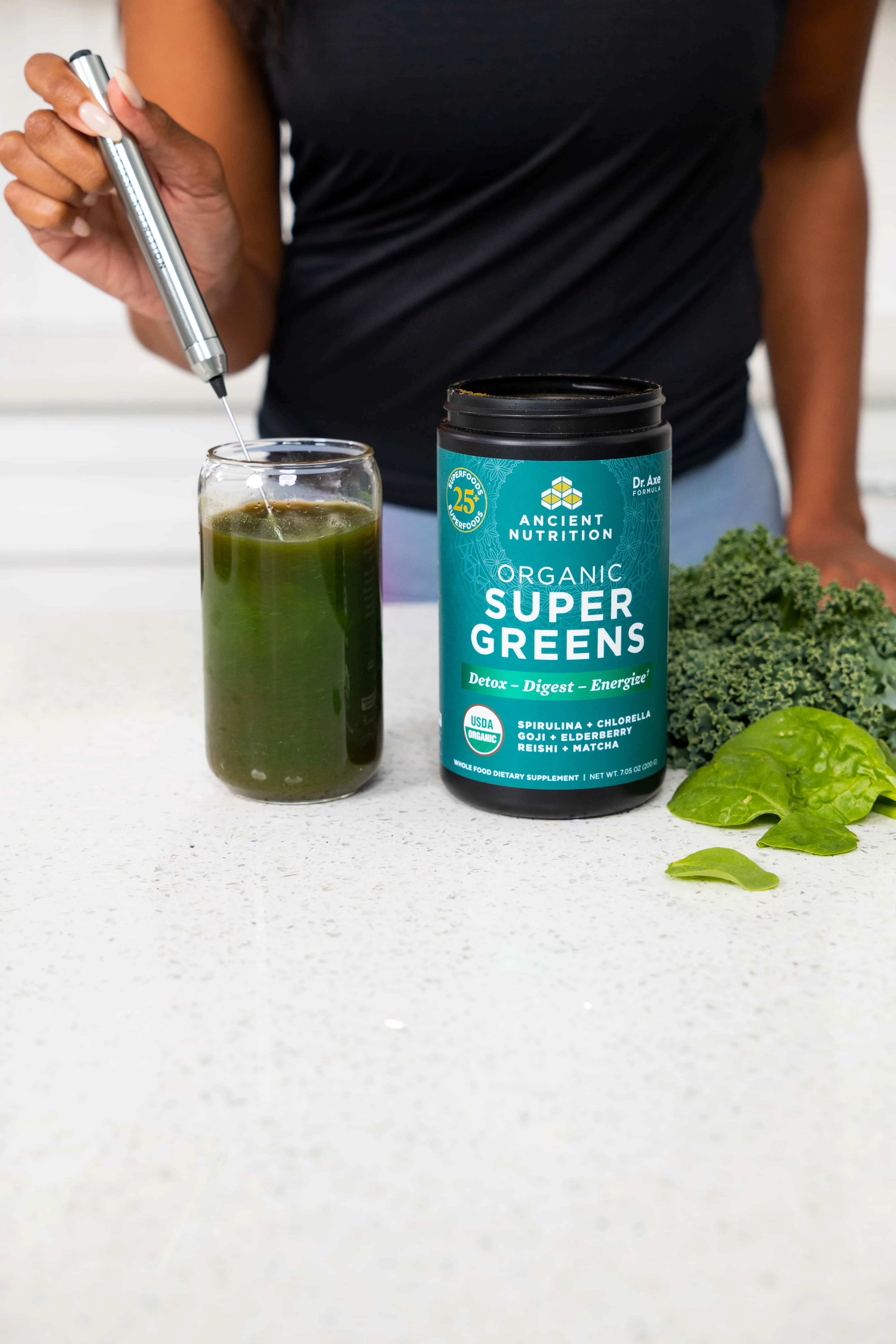 a person using a frother with organic supergreens