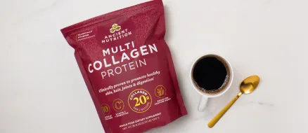 Multi Collagen Protein Powder Pure 100serv bag next to a cup of coffee