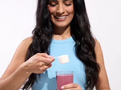 a woman holding a scoop of collagen