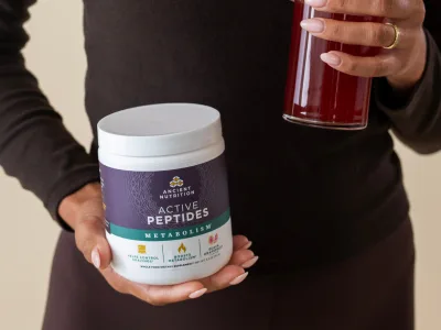 a person holding a bottle of Active peptides metabolism powder