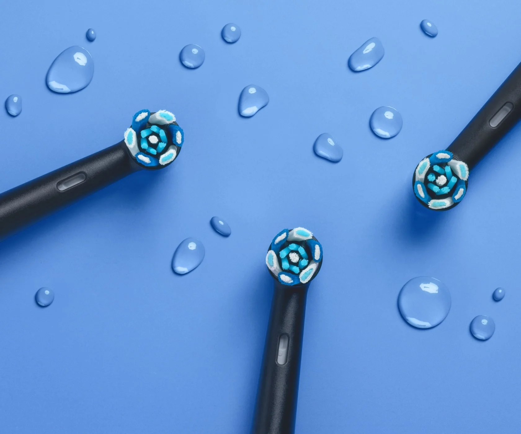 Grupo de cabeças de escova de reposição pretas Oral-B iO Ultimate Clean na superfície azul 