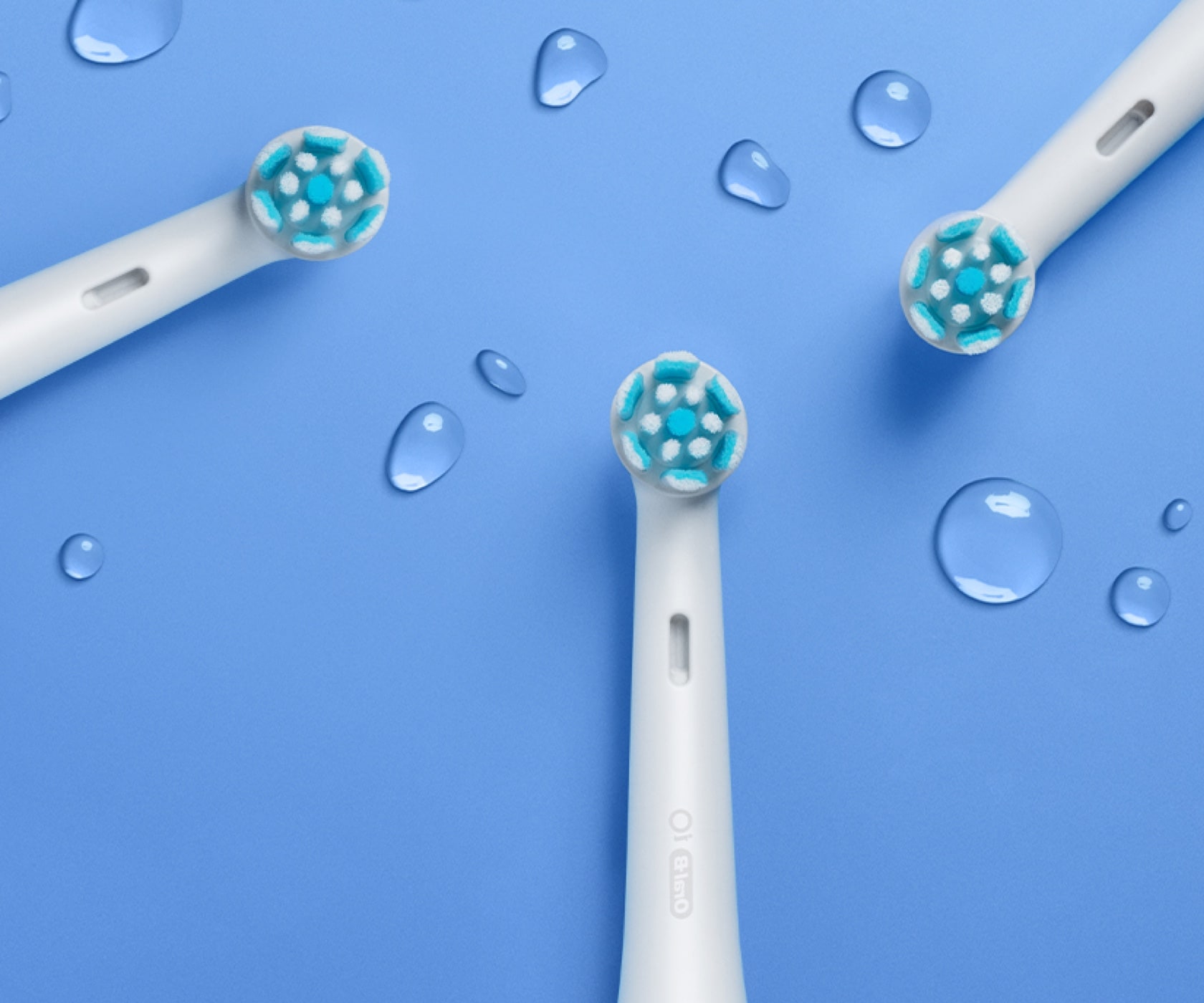 Group of white Oral-B iO Gentle Care replacement brush heads on blue surface undefined