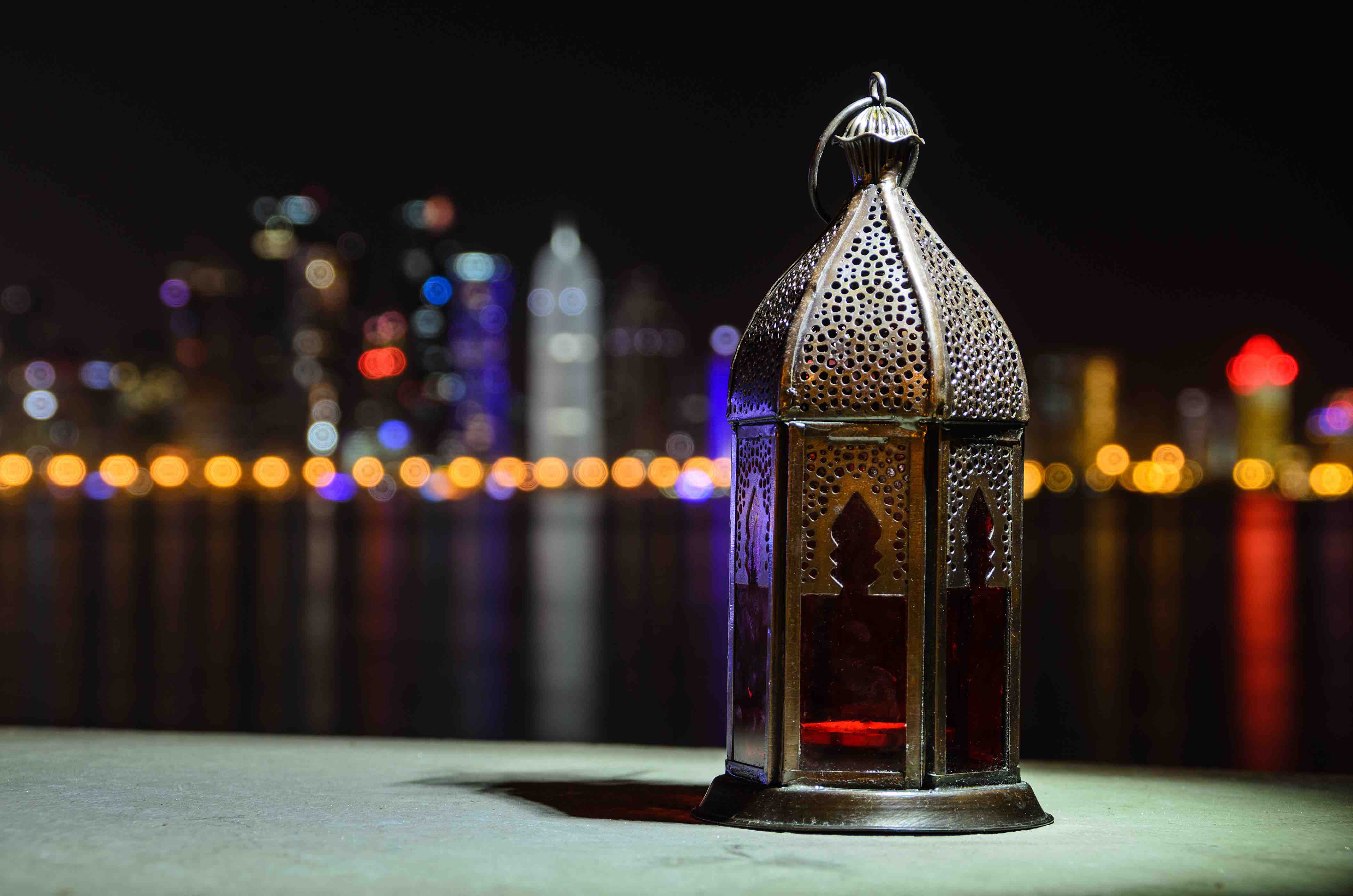 Vintage lantern. Ramadan mood at night with light of Doha city in the background - QF - 01