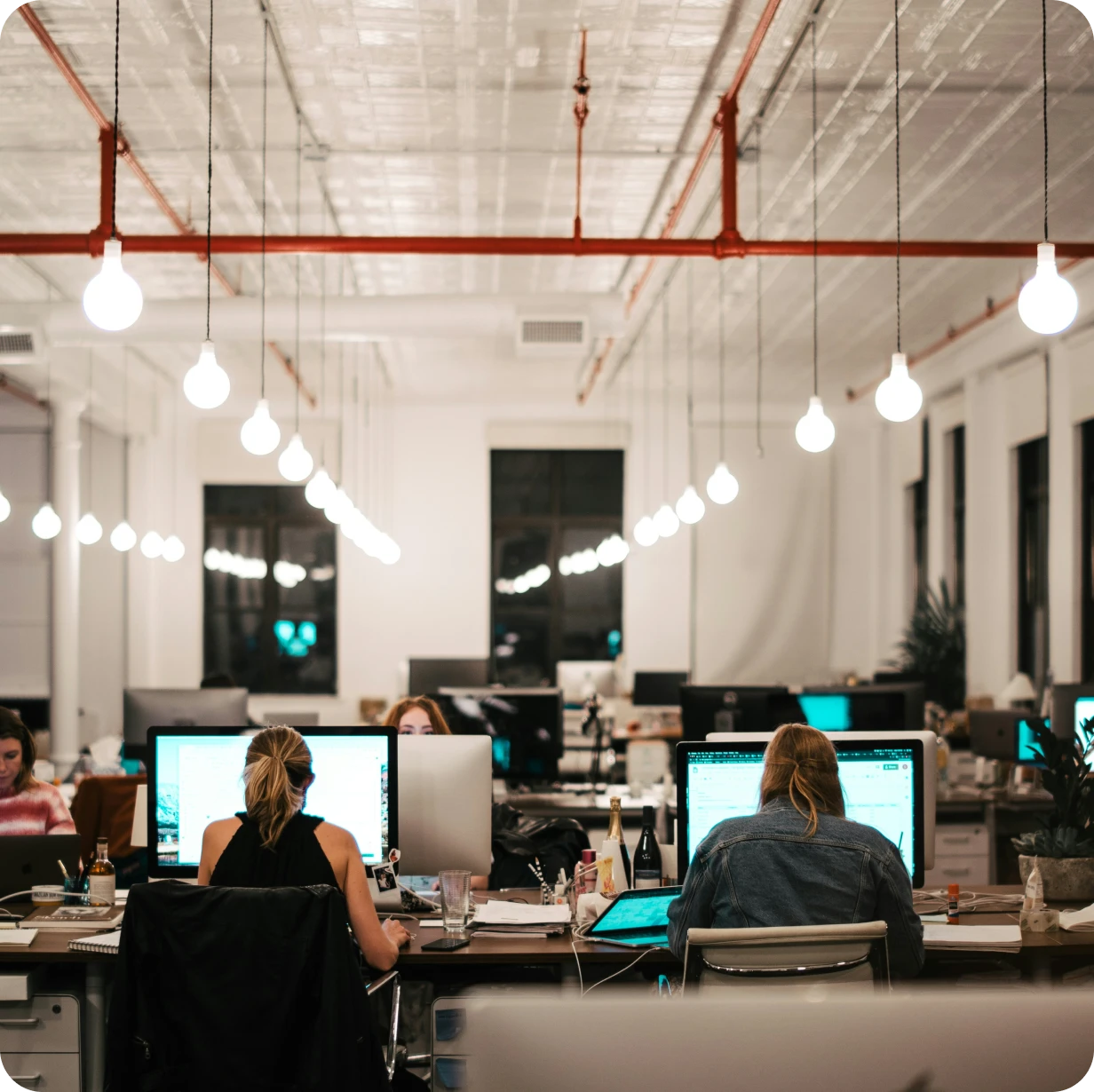 An open plan workspace with many employees working at computers