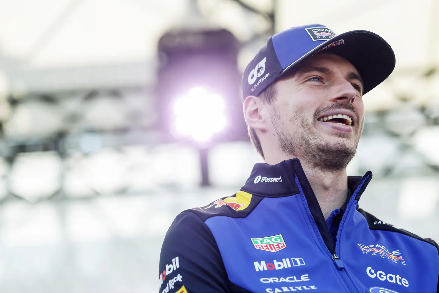 Formula 1 driver Max Verstappen smiling while wearing his Oracle Red Bull Racing team gear. 