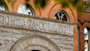 The exterior of a stone and brick building on Gonzaga University's campus is seen behind orange autumn leaves