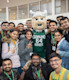 A group of smiling international students at Cleveland State University surrounding Magnus, the CSU mascot.