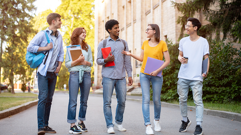 A group of international students at Shorelight universities walk together on campus between classes and talk about their study abroad experience in the US.