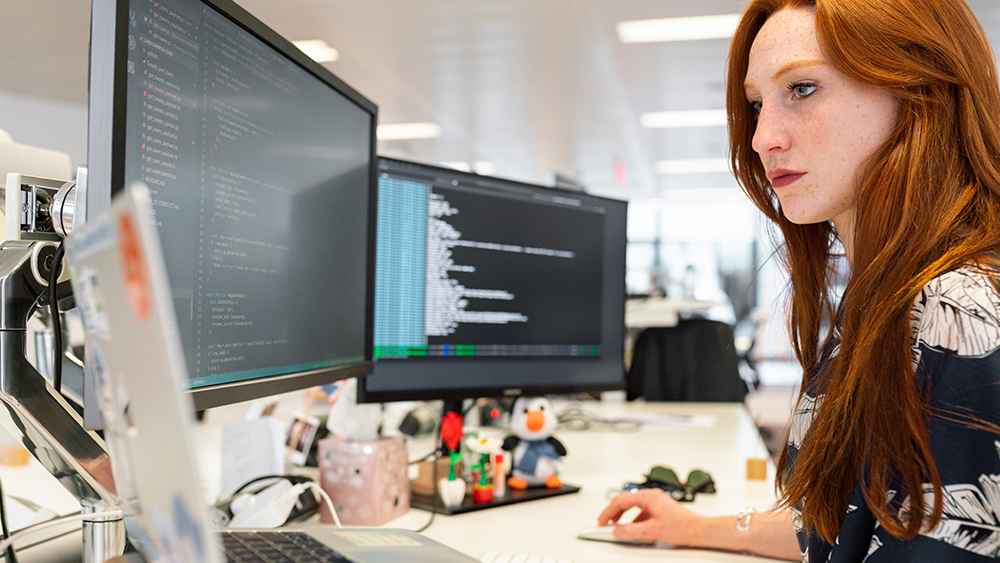 This photo shows a female international student sitting at a STEM internship in the USA, which she got after applying for jobs for students and getting career guidance from Shorelight advisors. 