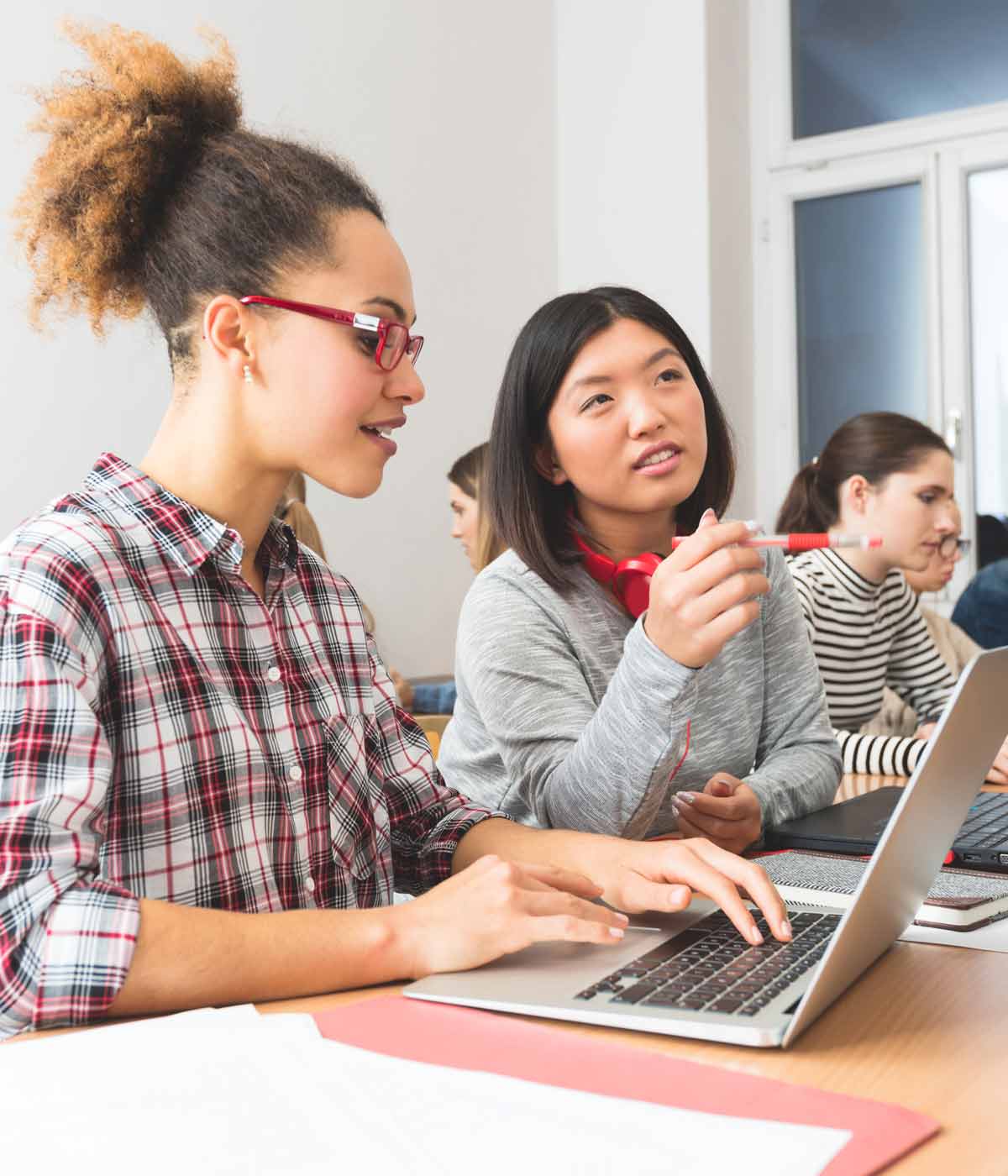 Two female students in a classroom discussion.