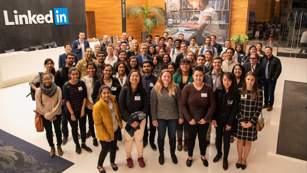 A group of college students from the University of the Pacific CO-OP program stand together in the lobby of LinkedIn's headquarters