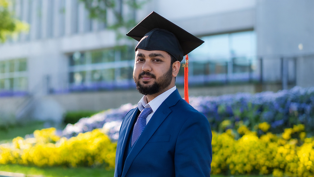 Suman, an international student from India at Cleveland State University, stands wearing a graduation cap after receiving his master's degree in software engineering.