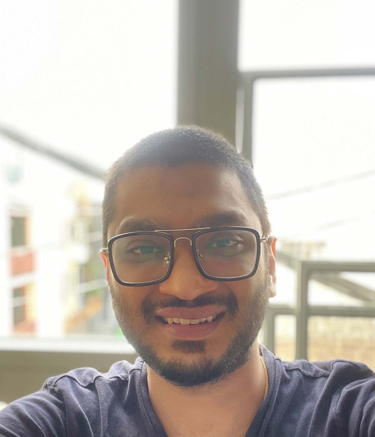 Nikhil, an international student at University of the Pacific, sits and smiles for the camera