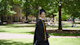 Chongbo, an economics student from China at the University of South Carolina, walks across campus in his graduation cap and gown