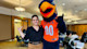 Leidy Bello Cristancho, student services advisor for international students at The University of Texas at San Antonio, stands with the Roadrunner mascot with both making the hand sign for UT horns. 