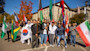 A group of international students at the University of Wisconsin-Platteville stand together on campus holding flags from their home countries