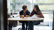 Two women, an international student and a counselor, discuss possible US university majors, while sitting at a desk.