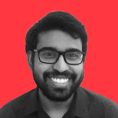 This headshot photo shows Bhanujith Wijesinghe of Surge Global smiling for the camera against a red background