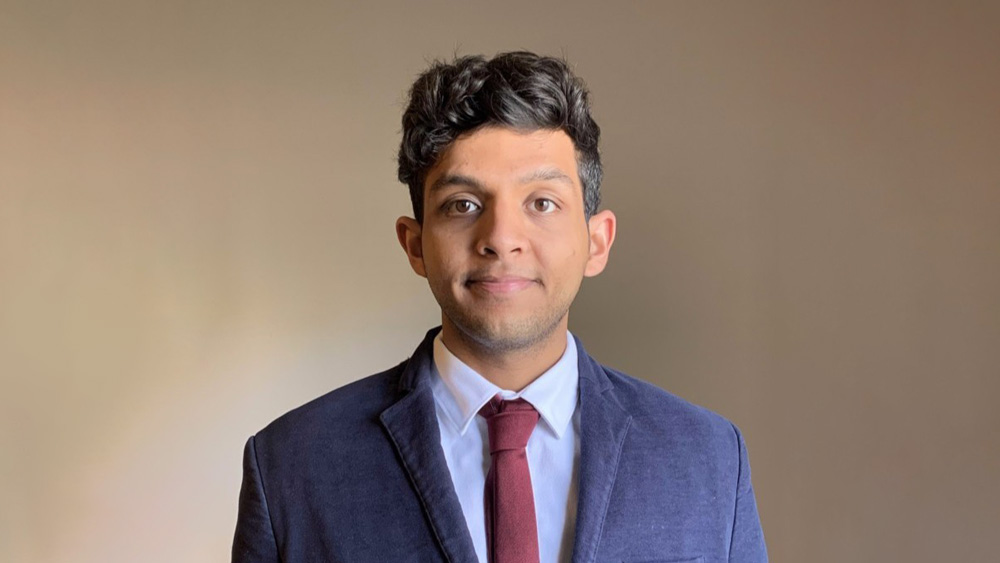 Anas, an international student from Saudi Arabia at the University of South Carolina, smiles at the camera while wearing a suit jacket and tie