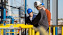 Three international students at LSU wear hard hats while working outside at the PERTT petroleum engineering lab 