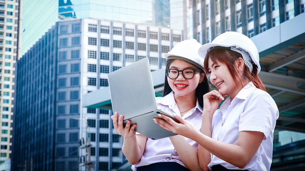 Two architecture students studying together using a computer