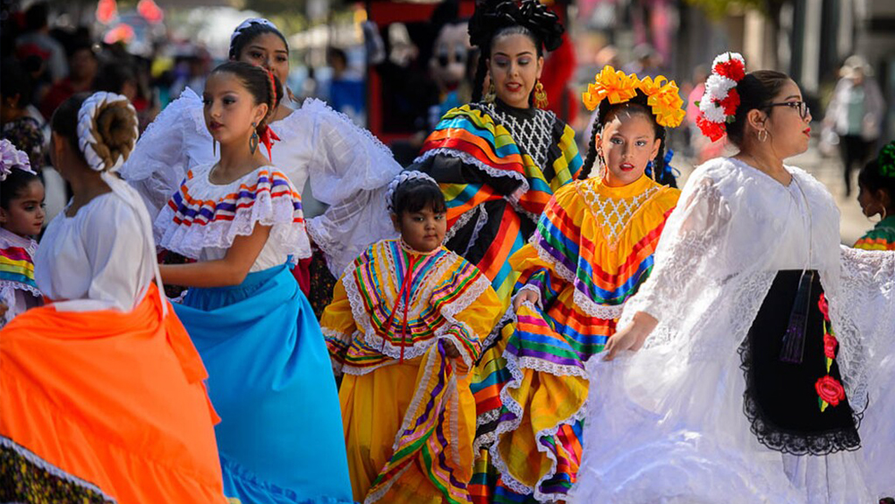 A group of Latina women in traditional dress dance for a festival in Salt Lake City.