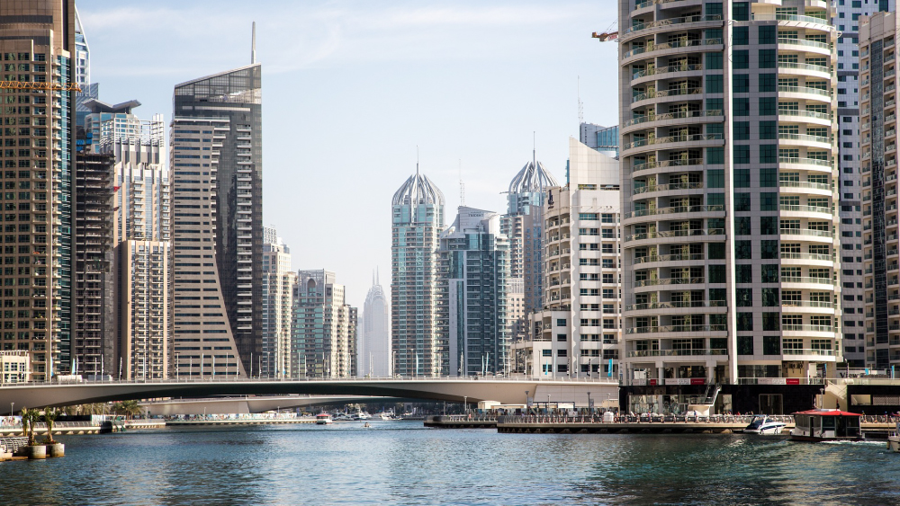 The Dubai skyline towers stand tall above the Dubai Water Canals, not too far from Heriot-Watt University Dubai, a Shorelight university