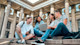 A group of international students sit outside on the steps of a campus building at their US university.