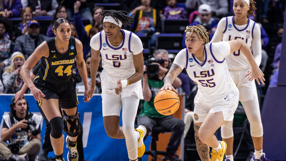 Three LSU women's basketball team athletes actively playing during a game.