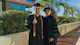 Sen Zhang, an international computer science major from China, stands next to his professor on the University of South Carolina campus, wearing his cap and gown on graduation day after receiving his bachelor degree.
