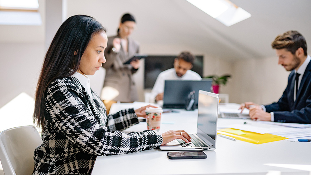 IT professional working at a table with co-workers