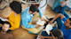 A small college study group sits on the floor each holding open the book being discussed.