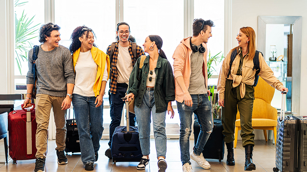 A group of international students with suitcases arrive at their dormitory on move in day for their student exchange program.