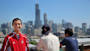 Two University of Illinois - Chicago students on a rooftop with one facing the camera and the other facing the Sears (Willis) Tower in the background.