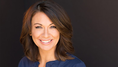 Shorelight author Christy Jacks smiles for the camera against a dark background