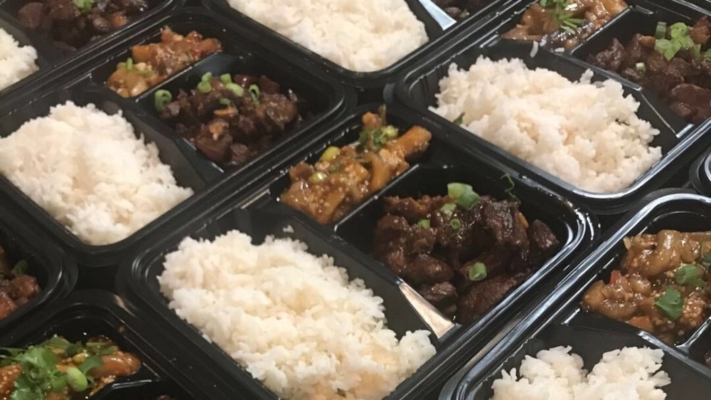 A display of takeout meals for international students at Auburn University with to-go meals including bao, rice noodles, vegetables, and dumplings.