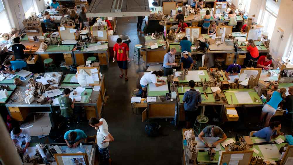 Overhead shot of many international students drawing up blueprints at individual workstations