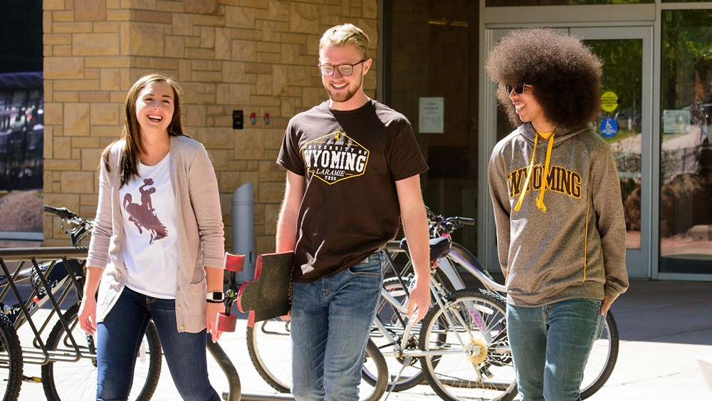 Three students from the University of Wyoming walking together on campus.