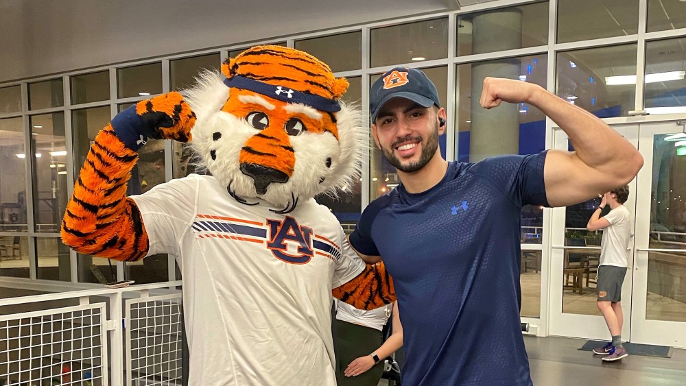 Roberto, an international student from Brazil at Auburn University, stands in the crowd at a Tigers football game with his wife, Katie. 